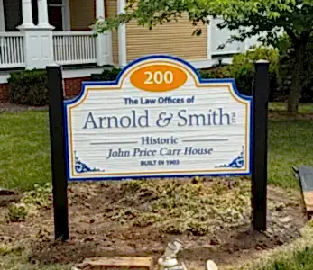 Signboard for The Law Offices of Arnold & Smith in front of a historic house (John Price Carr House, built 1903).